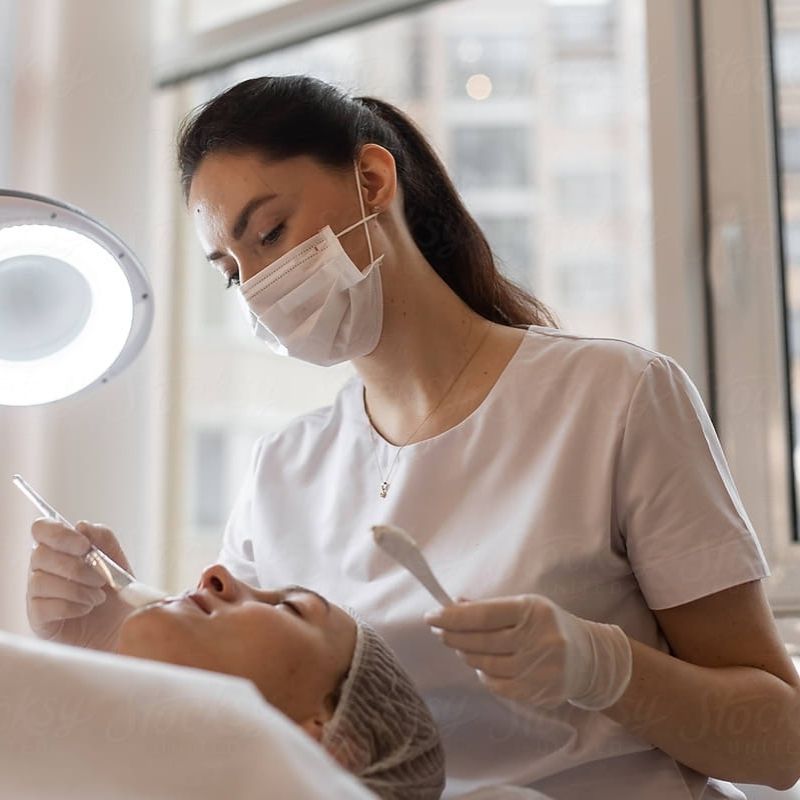 Skincare professional performing a facial treatment in clinic, supporting healthy-looking skin with expert-led care